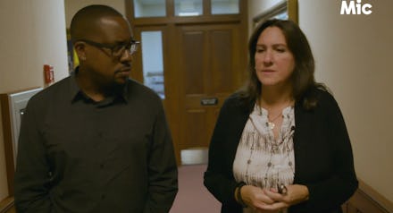 A man and a woman walking down a hall and talking about voting machines that could be susceptible to...