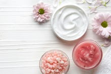 Two bowls with white, and pink cream in it, and a bowl with pink Himalayan salt, and two light pink ...