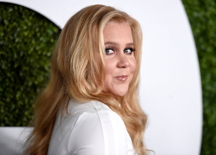 Amy Schumer in a white shirt looking over her shoulder