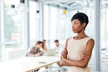 A business woman standing in her office and looking through the window