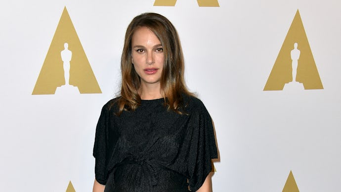 Natalie Portman posing in a black dress at the Oscars