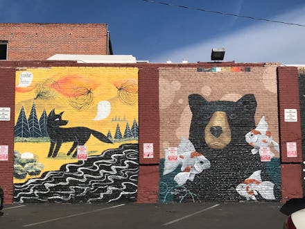 Big graffiti drawings of fox and bear on a brick wall