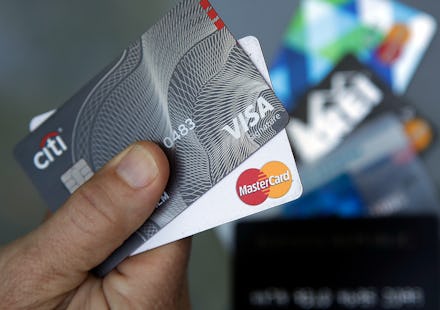 A person holding Visa and Mastercard credit cards
