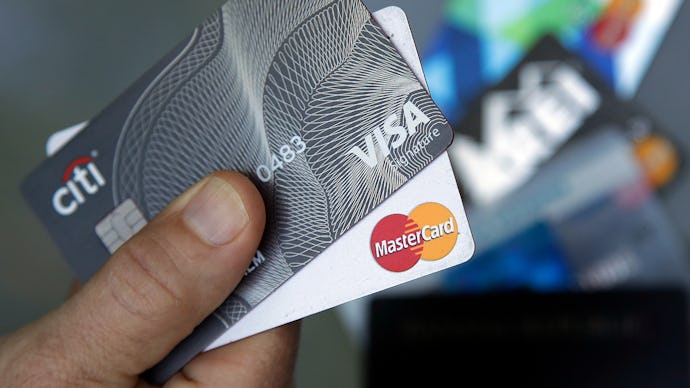 A person holding Visa and Mastercard credit cards