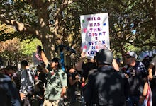 Milo Yiannopoulos’ free speech rally in UC Berkeley with someone holding a sign that reads milo has ...