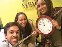 Two women and a man have taken their clock off the wall to stand with ahmed mohamed