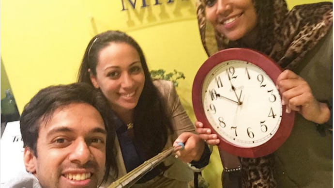 Two women and a man have taken their clock off the wall to stand with ahmed mohamed