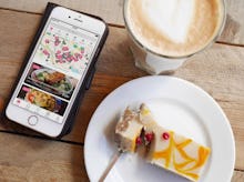 Food app on phone and a plate with cheesecake and a fork