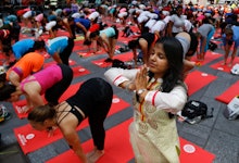 People doing Yoga in Lululemon yoga equipment and an Indian woman doing Yoga in traditional Indian y...