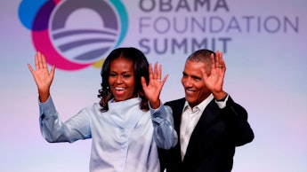 Michelle and Barack Obama waving to the audience at the obama foundation summit