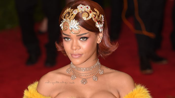 Rihanna wearing a furry yellow outfit and an extravagant head band at a red carpet event