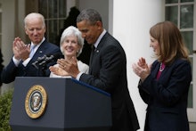 Barack Obama giving a speech next to Joe Biden and two women