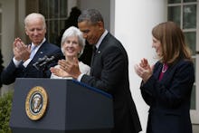 Barack Obama giving a speech next to Joe Biden and two women