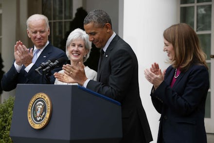 Barack Obama giving a speech next to Joe Biden and two women