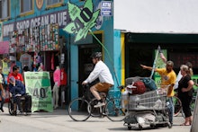 A man riding a bike next to a marijuana shop