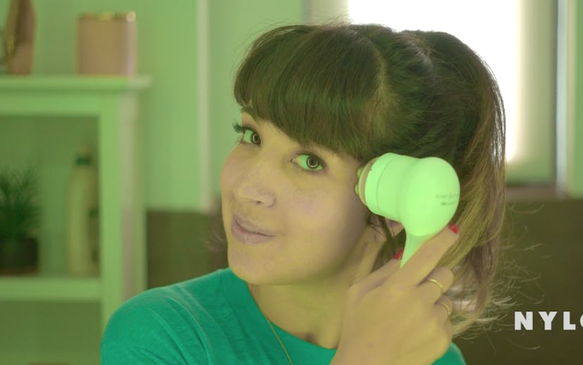 A brunette girl using the Clarisonic Mia Smart face brush