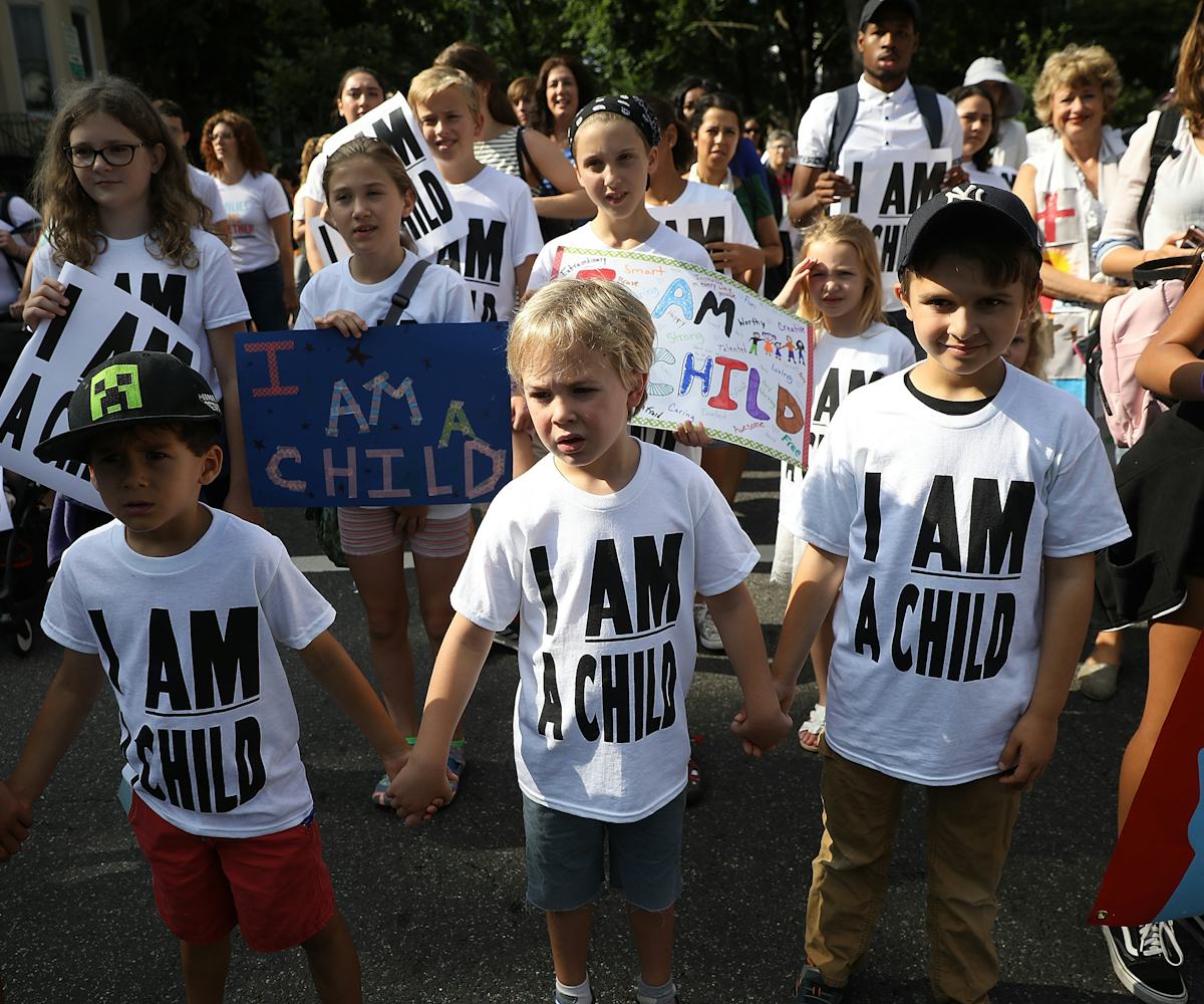 Children protesting with white shirts that have black "I am a child" text printed