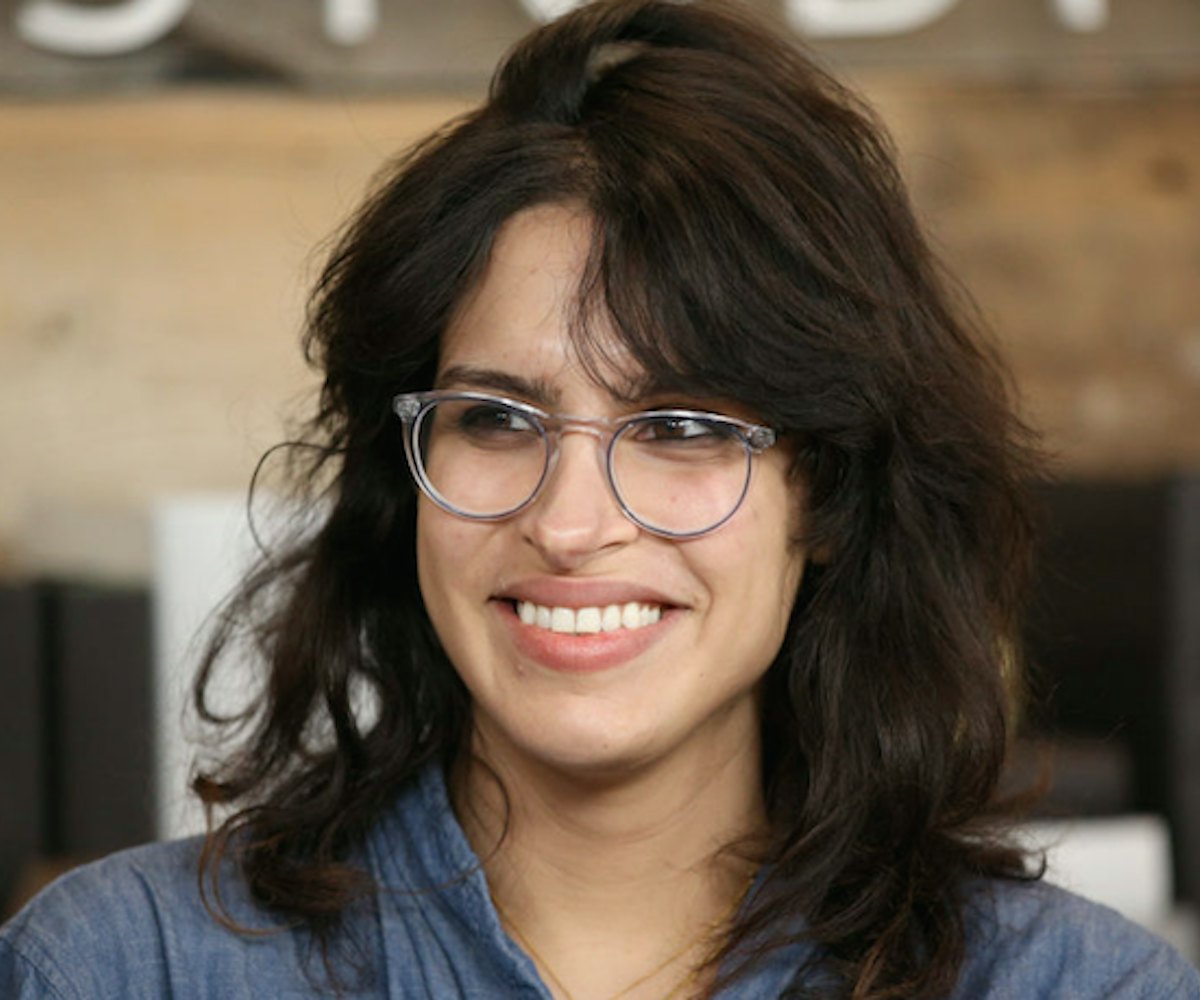 Desiree Akhavan wearing a pale navy linen shirt and translucent glasses