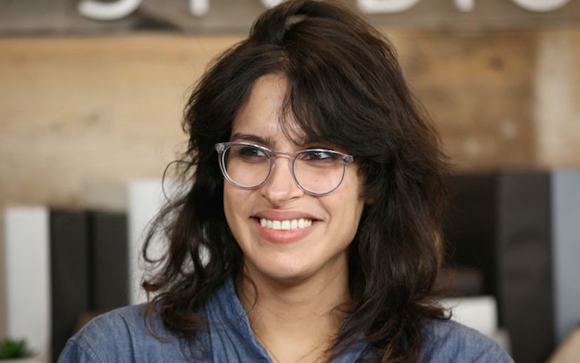 Desiree Akhavan wearing a pale navy linen shirt and translucent glasses