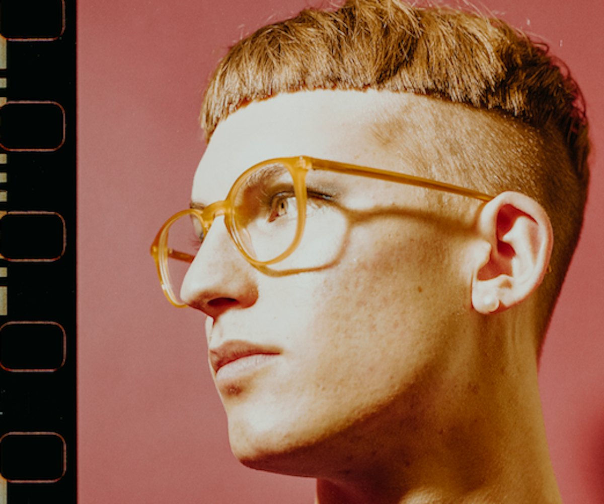 Gus Dapperton with a bowl cut hairstyle and orange glasses