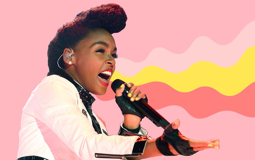 Janelle Monáe singing in front of the pink background while wearing a white jacket