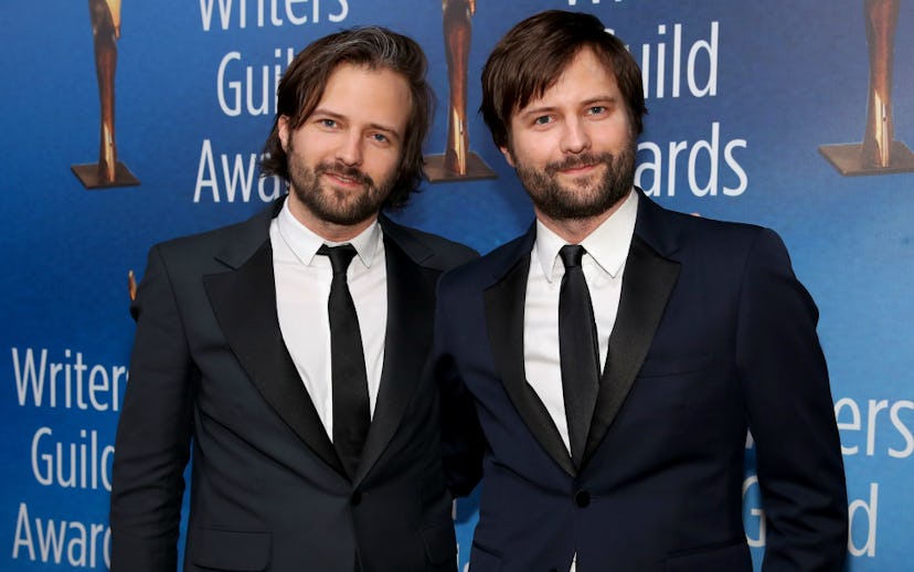 Matt and Ross Duffer posing while wearing black and white suits