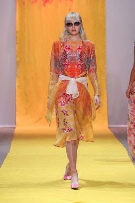 A model walking in a yellow and orange gown 