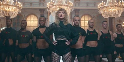 Taylor Swift is standing next to the seven men while wearing dark clothes for the music 'Look what y...