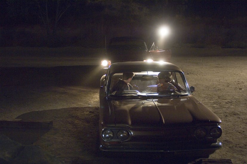 Zodiac cover with two cars at an empty parking lot