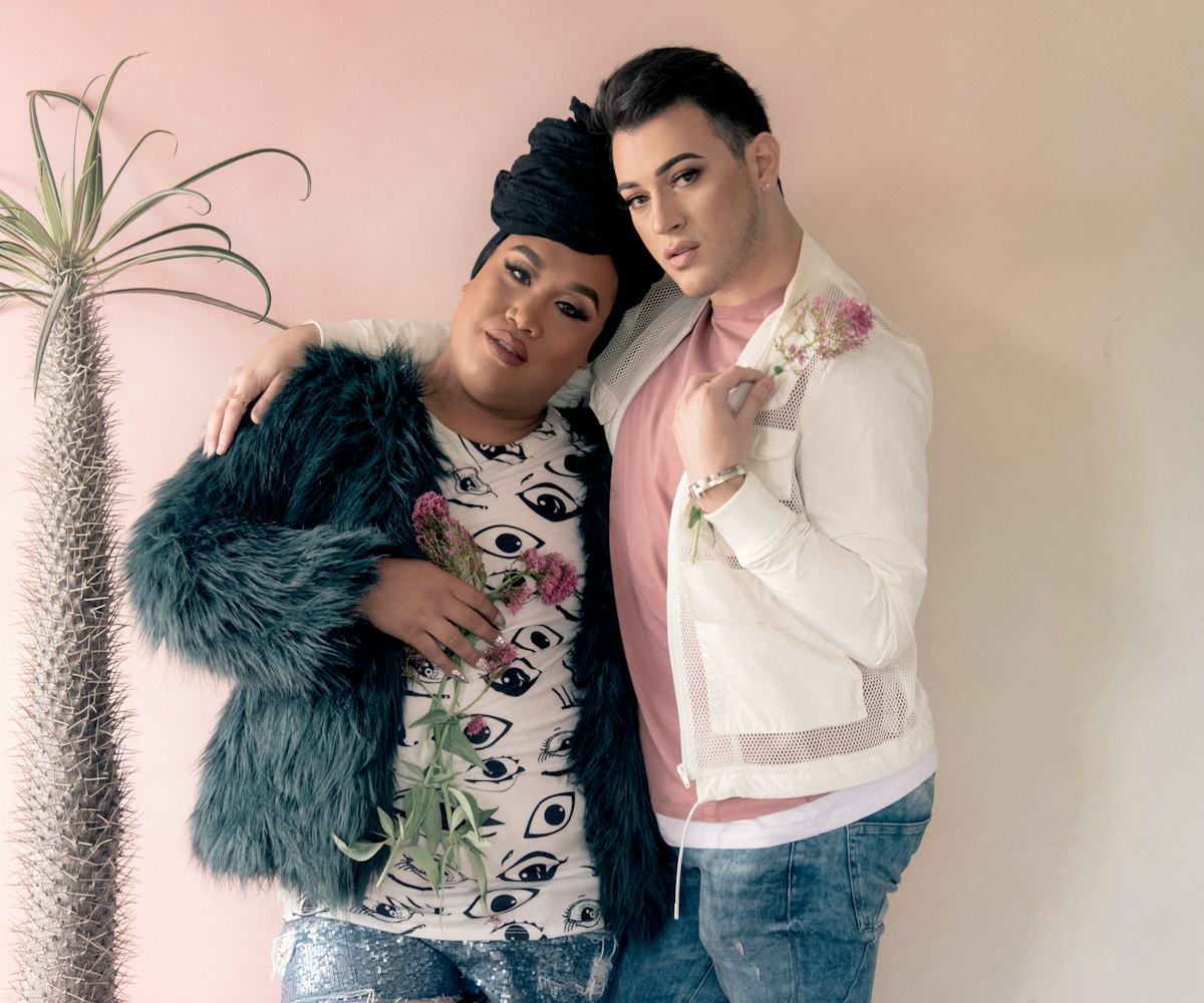 Manny Mua in a pink shirt, white jacket, and blue denim jeans and Patrick Starrr in a black-white sh...