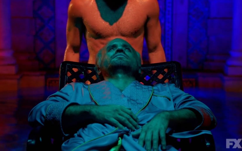 A man in blue light and man behind him from the American crime story Assassination of Gianni Versace...
