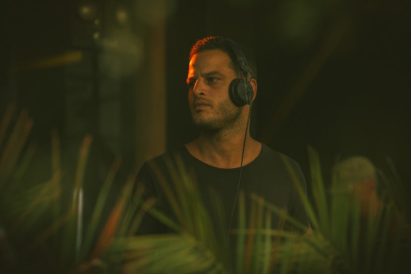 Moroccan DJ Amine K casting a serious glance to the side while wearing headphones