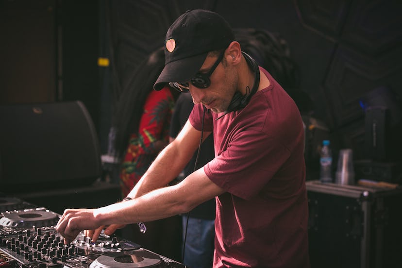 DJ Driss Skali from Morocco performing while wearing a maroon shirt, a black cap, and sunglasses