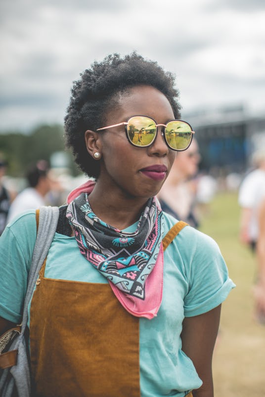 Girl posing in a fun colorful outfit with a berry colored lipstick, while rocking short afro hair