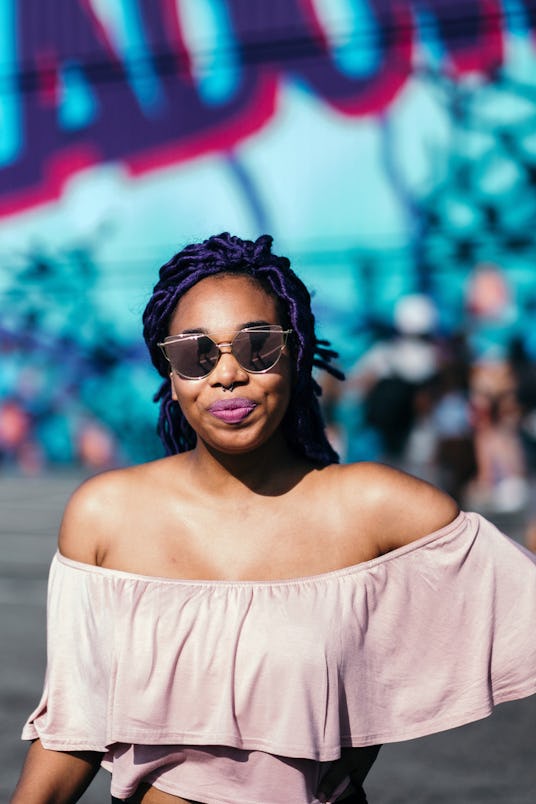 A girl in a simple pink top and sunglasses