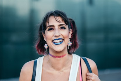 A girl with a choker, lollipop earrings, and a metallic blue lipstick