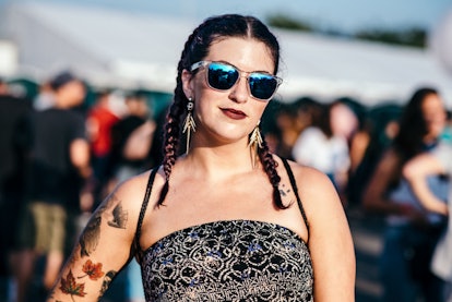Girl with two braids on each side while wearing blue reflective sunglasses