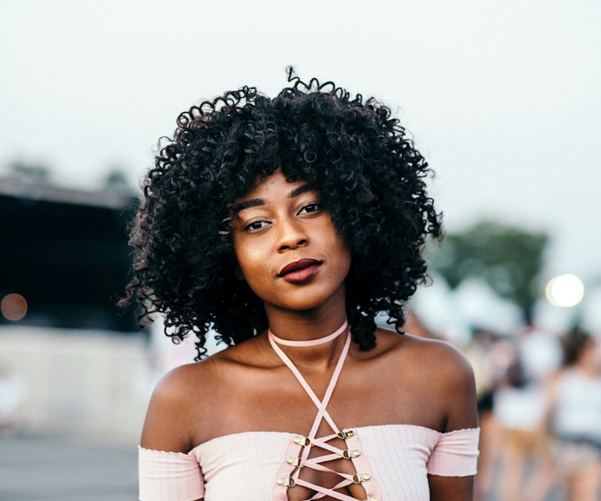 A girl with afro hairstyle in a light pink top
