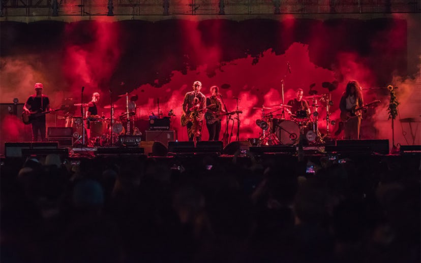 A band on stage with smoke and red lighting all around