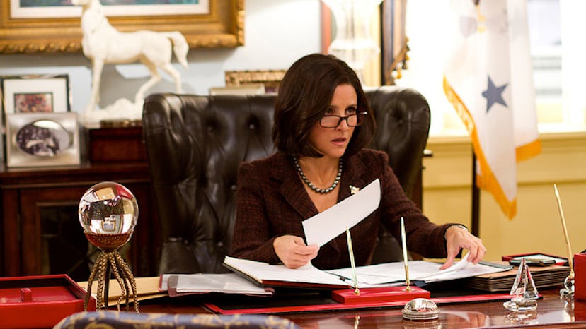 Julia Louis-Dreyfus sifting through papers at a desk in Veep 
