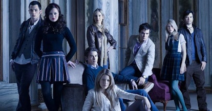 The main cast of Gossip Girl posing for a series poster in dim lighting 