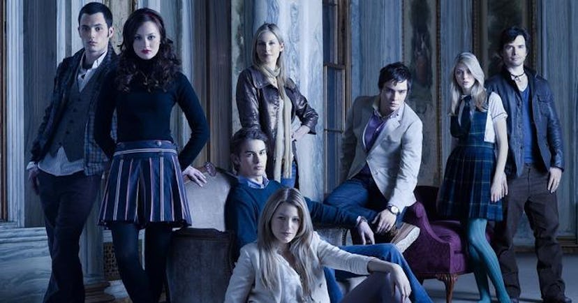 The main cast of Gossip Girl posing for a series poster in dim lighting 