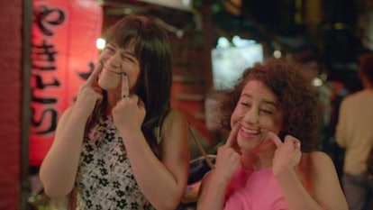 Ilana Glazer and Abbi Jacobson raising smiles on their mouths using their middle fingers Broad City