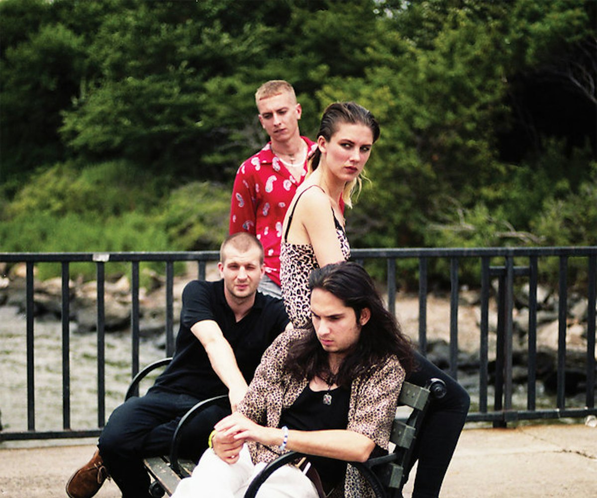 Band members of Wolf Alice posing on a bench and all looking into the distance
