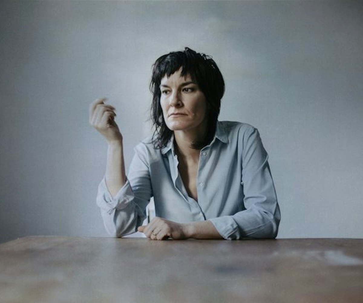 Jen Cloher, an Australian singer sitting on a grey background 