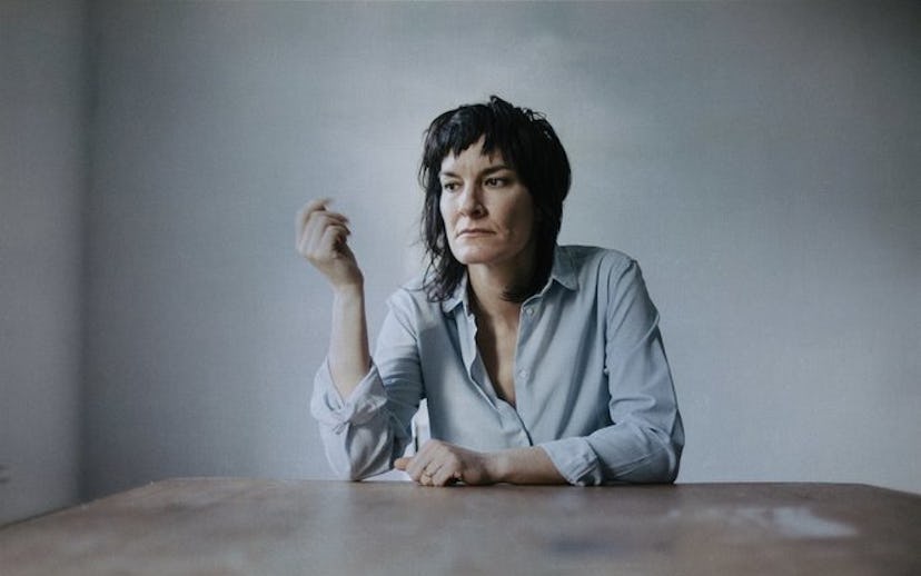 Jen Cloher, an Australian singer sitting on a grey background