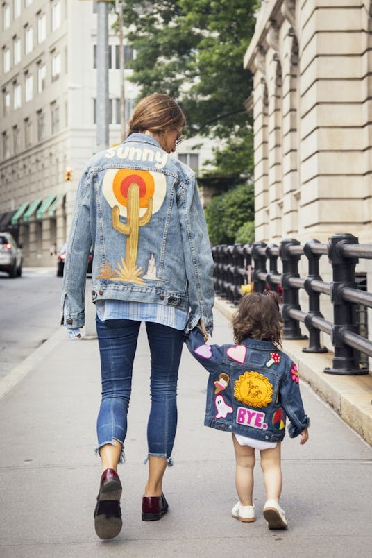 A woman and a little girl wearing matching Levi's denim jackets with stickers on the back