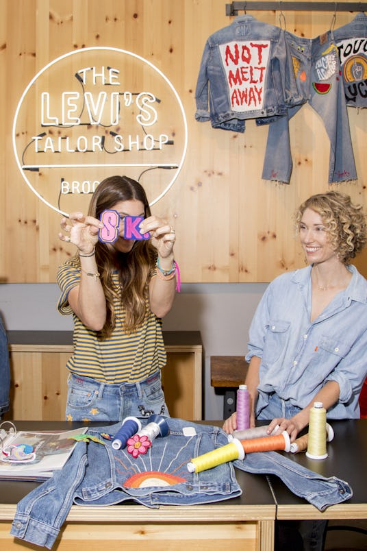 Two girls enjoying themselves decorating denim jackets