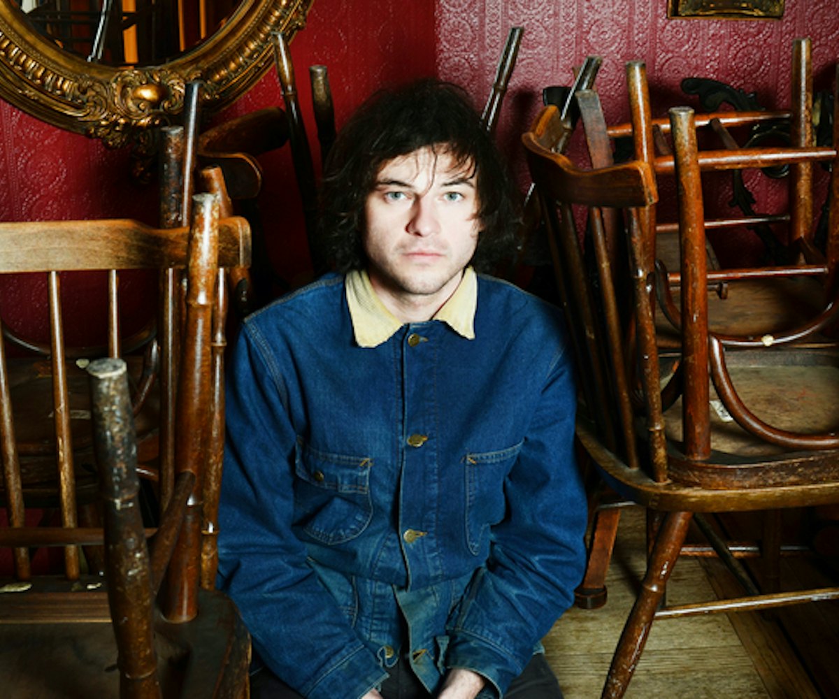 Ryley Walker sitting in a closed bar with chairs on the tables