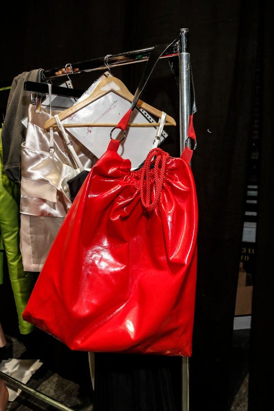 Big shiny red purse hanging on a rack backstage at Amsterdam Fashion Week 